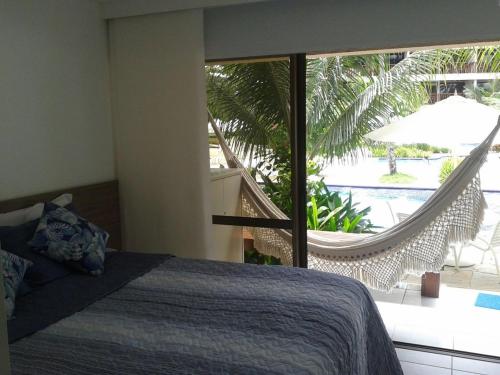 嘎林海斯港Nannai Residence Flat的一间卧室配有一张床,阳台配有吊床