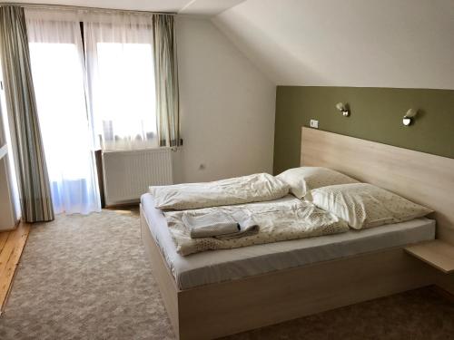 Dunabogdány赫尔罗德旅馆的一间卧室配有一张大床和床头板