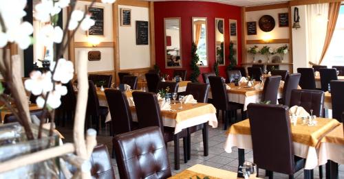 雄济耶The Originals City, Hôtel du Faucigny, Cluses Ouest的一间在房间内配有桌椅的餐厅