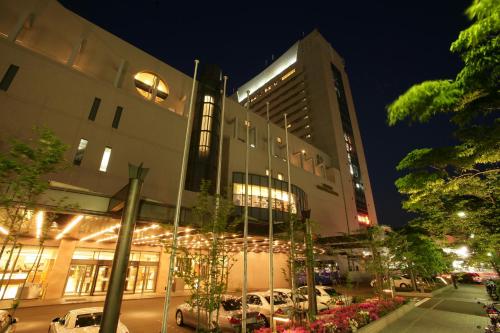 神户神户西神东方酒店的一座有汽车在晚上停在停车场的建筑