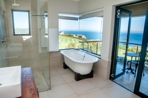 克尼斯纳Hippo House的带浴缸的浴室,享有海景。