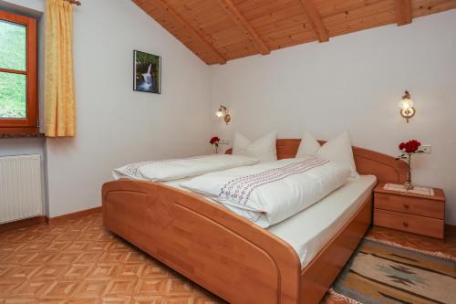维兰德罗马尔塞特霍夫农家乐的一间卧室配有一张带白色床单的木床