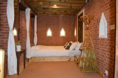 帕坦扬巴传统住宿加早餐旅馆的卧室配有砖墙内的床铺