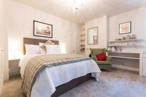 威布里治April House Weybridge - Boutique Guesthouse的一间卧室配有一张床和一把绿色椅子