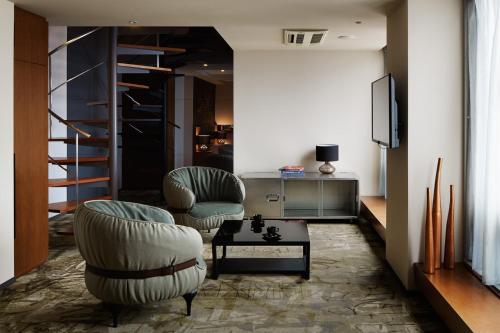 东京格兰贝尔酒店的客厅配有两把椅子和电视