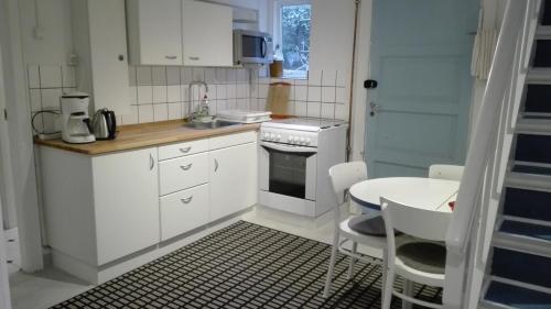 哥本哈根哥本哈根皇家住宿酒店的厨房配有白色橱柜、桌子和炉灶。