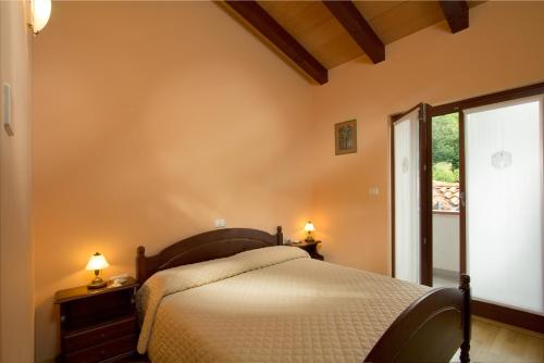 PodsabotinTuristična kmetija Štanfel的一间卧室设有一张床和一个大窗户