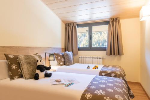 博尔德斯·代瓦里拉Pierre & Vacances Andorra Sunari Peretol的一间卧室设有两张床,里面饲养着动物。