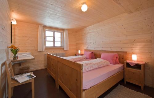 Wergenstein魔羯酒店餐厅的小木屋内一间卧室,配有一张床