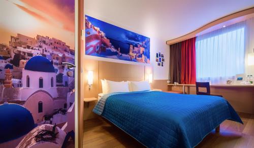华沙华沙雷杜塔宜必思酒店的酒店客房设有蓝色的床和窗户。