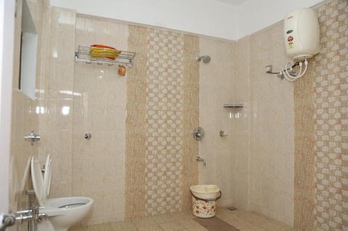 KalasaHotel Mudra Midtown Suites & Rooms的带淋浴、卫生间和盥洗盆的浴室