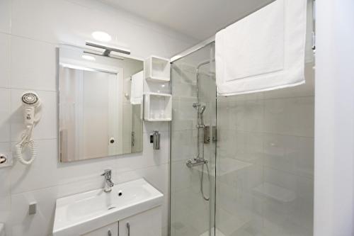 圣地亚哥－德孔波斯特拉Apartamentos Pombal的带淋浴、盥洗盆和镜子的浴室