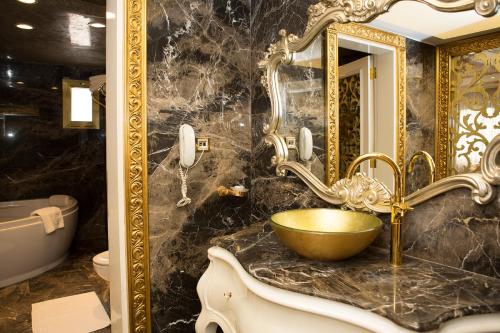 伊斯坦布尔布宇克哈米特酒店的浴室设有金色水槽和镜子