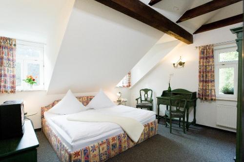 巴特尚道弗尔斯特豪斯酒店的卧室配有床、书桌和钢琴