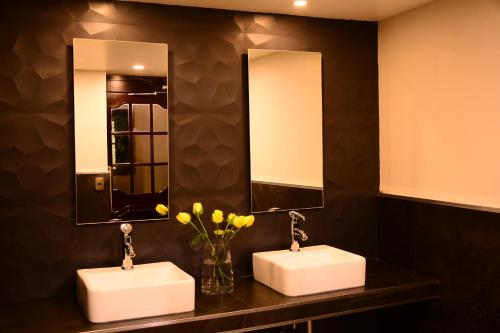 贾拉普帝国酒店的浴室内设有2个水槽,配有2面镜子和鲜花
