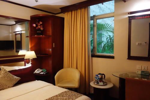 澳门万事发酒店的酒店的客房 - 带一张床、椅子和窗户