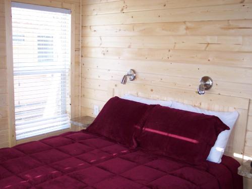 克罗弗戴尔Russian River Camping Resort Cottage 7的一间卧室配有一张红色的床和木墙