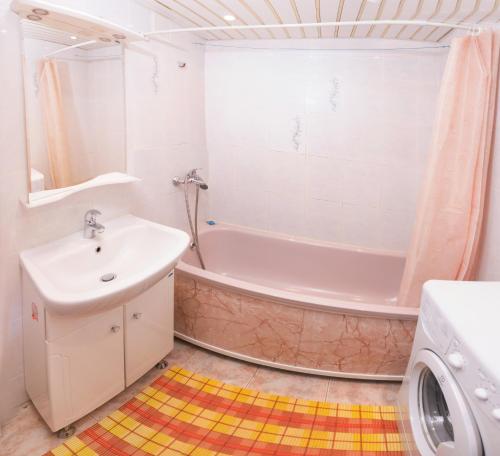 秋明Apartment on Sverdlova的带浴缸、水槽和洗衣机的浴室