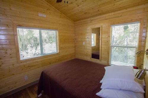 Descanso欧克扎尼塔温泉营地3号度假屋的小木屋内一间卧室,配有一张床