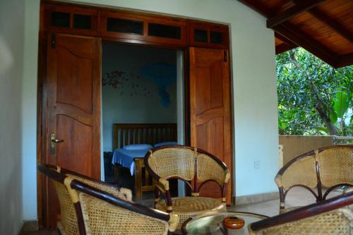波隆纳鲁沃碧纳兰民宿的一间带椅子和桌子的房间以及一扇门