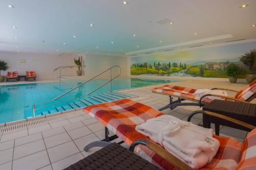 汉堡汉堡新生活酒店的一个带躺椅的大型游泳池和一个游泳池
