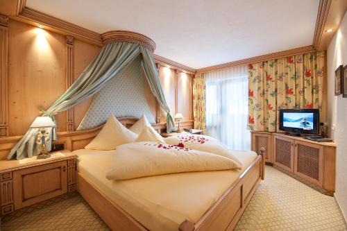 奥伯古格尔Hotel Jagdhof Bed & Breakfast的酒店客房,配有床和电视