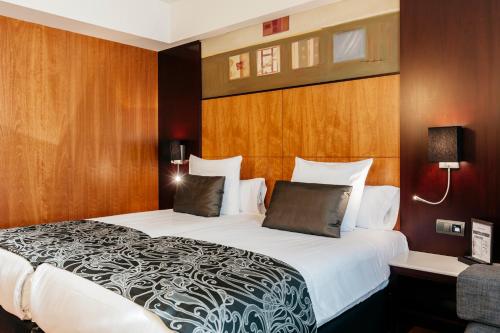 布鲁塞尔Catalonia Brussels的一间卧室配有一张带木墙的大床