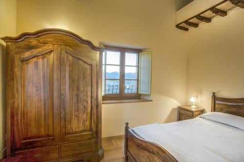 法布里亚诺拉卡斯提亚度假酒店的一间卧室设有一张木床和一个窗户。