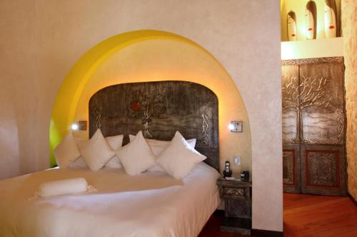 克雷塔罗Casona de la Republica Hotel Boutique & SPA的一间卧室配有一张大床,上面有拱门