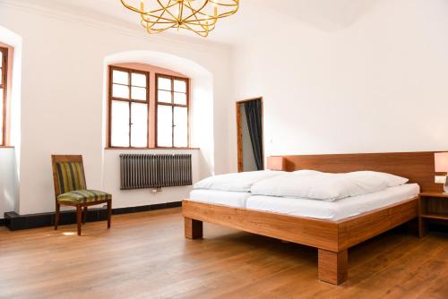 埃尔特维勒Weinhotel Koegler的一间卧室配有一张床、一张桌子和一把椅子