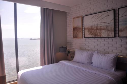 马卡萨马卡萨艾克普利西亚酒店的酒店客房设有一张床和一个大窗户