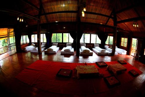 萨帕PO民宿的客房铺有木地板,配有白色枕头。