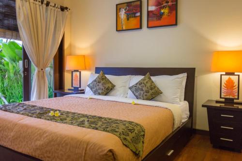 乌鲁瓦图巴厘岛海滩丽嘉别墅的一间卧室配有一张带两盏灯的床和一扇窗户。