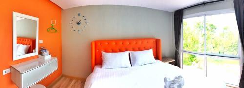 甲米镇博克斯之家度假村的橙色卧室配有床和镜子