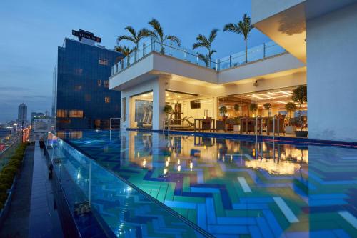 科伦坡科伦坡桔子酒店的一座晚上设有游泳池的建筑