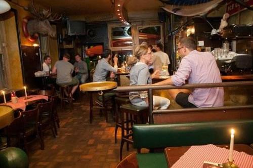 海德堡Hemingway`s Heidelberg Hostel的一群人坐在餐厅酒吧里