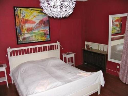 海德堡Hemingway`s Heidelberg Hostel的卧室配有白色的床和红色的墙壁