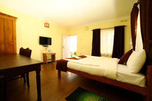 钦纳卡纳Holiday Heaven Munnar的一间卧室配有一张床、一张书桌和一台电视