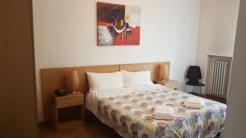 都灵圭多雷尼酒店的卧室配有一张床,墙上挂有绘画作品