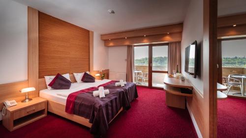欧罗什哈佐Hotel Corvus Aqua的酒店客房设有一张床和一个阳台。