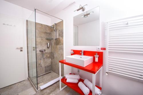 珀尔蒂尼什Pensiune Rara Paltinis的一间带红色水槽和淋浴的浴室