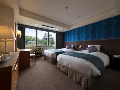 熊本熊本KKR酒店的酒店客房设有两张床和大窗户。