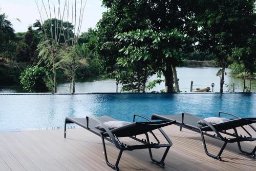 尖竹汶利维尔拉旺酒店的两把椅子坐在游泳池附近的甲板上