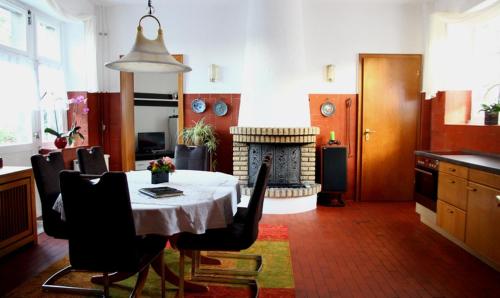 哈根戈德堡自然色别墅酒店的一间带桌子和壁炉的用餐室