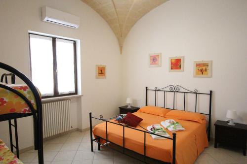 迪索B&B Borgo Antico的一间卧室配有橙色的床和窗户。