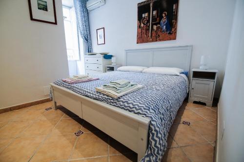 锡拉库扎福斯托公寓的一间卧室配有一张带蓝色和白色棉被的床