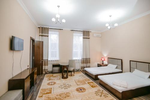 塔拉兹Hotel Inju的一间卧室配有两张床和一台平面电视