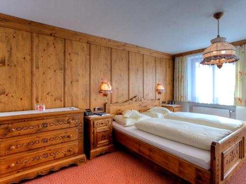 莱赫阿尔贝格步行者巴斯乡村民宿的一间卧室设有一张大床和木墙