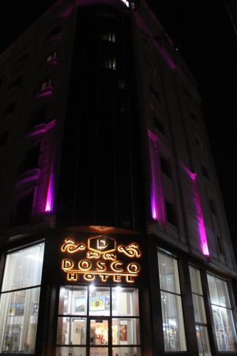 凡城Hotel Dosco的一座大建筑的侧面有标志