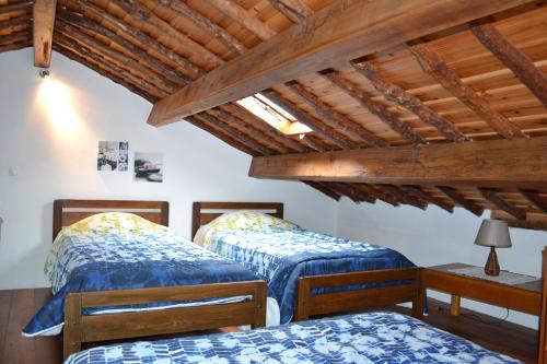 FeteiraCasa Doce Mar的配有木天花板的客房设有两张床。